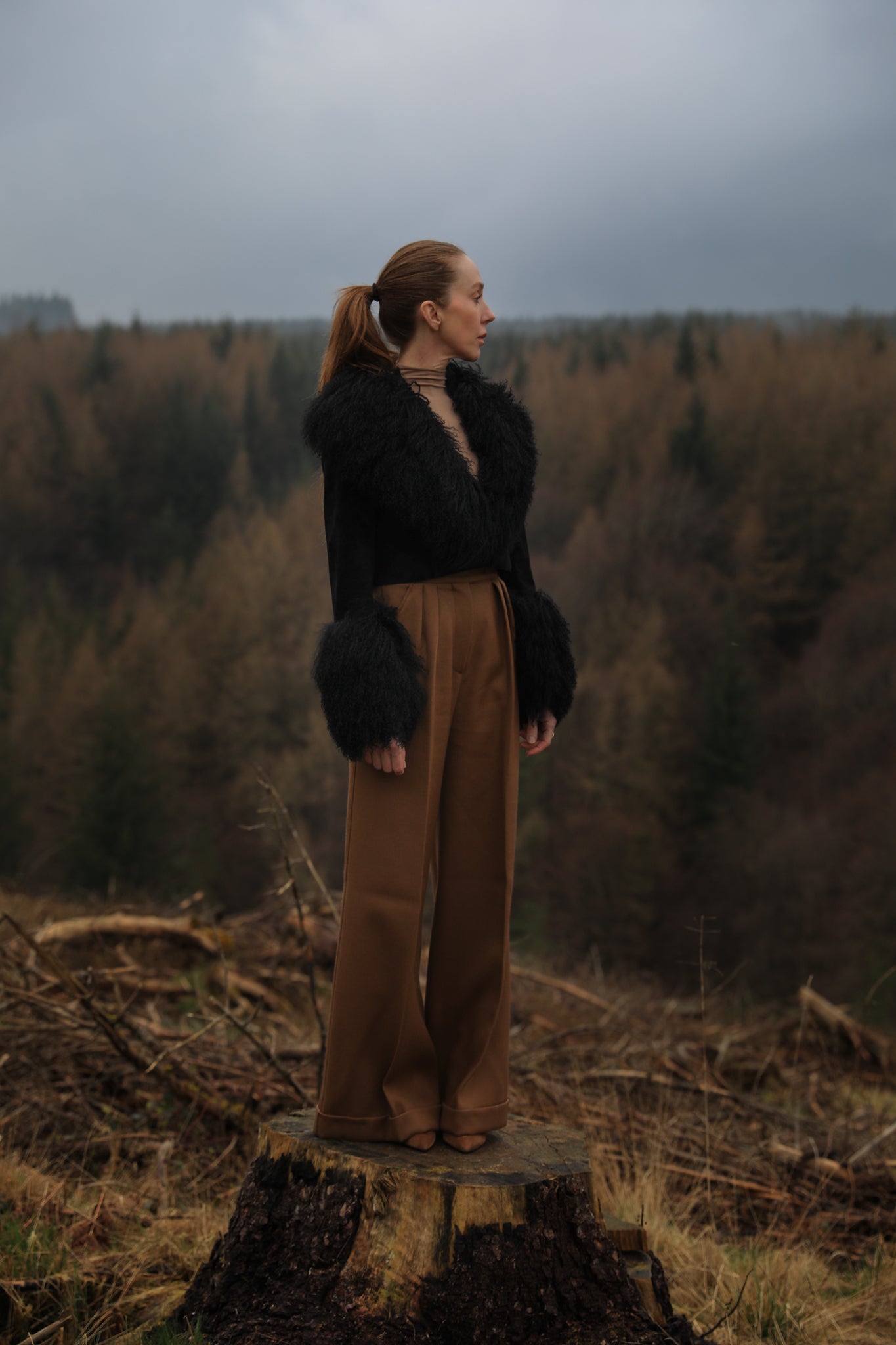 A sophisticated black genuine suede cropped jacket coat from Josephine Jones, featuring a luxurious Mongolian collar and cuffs. Perfect for adding a touch of elegance to any outfit.