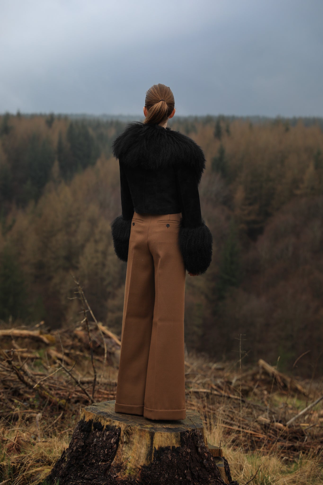 A sophisticated black genuine suede cropped jacket coat from Josephine Jones, featuring a luxurious Mongolian collar and cuffs. Perfect for adding a touch of elegance to any outfit.