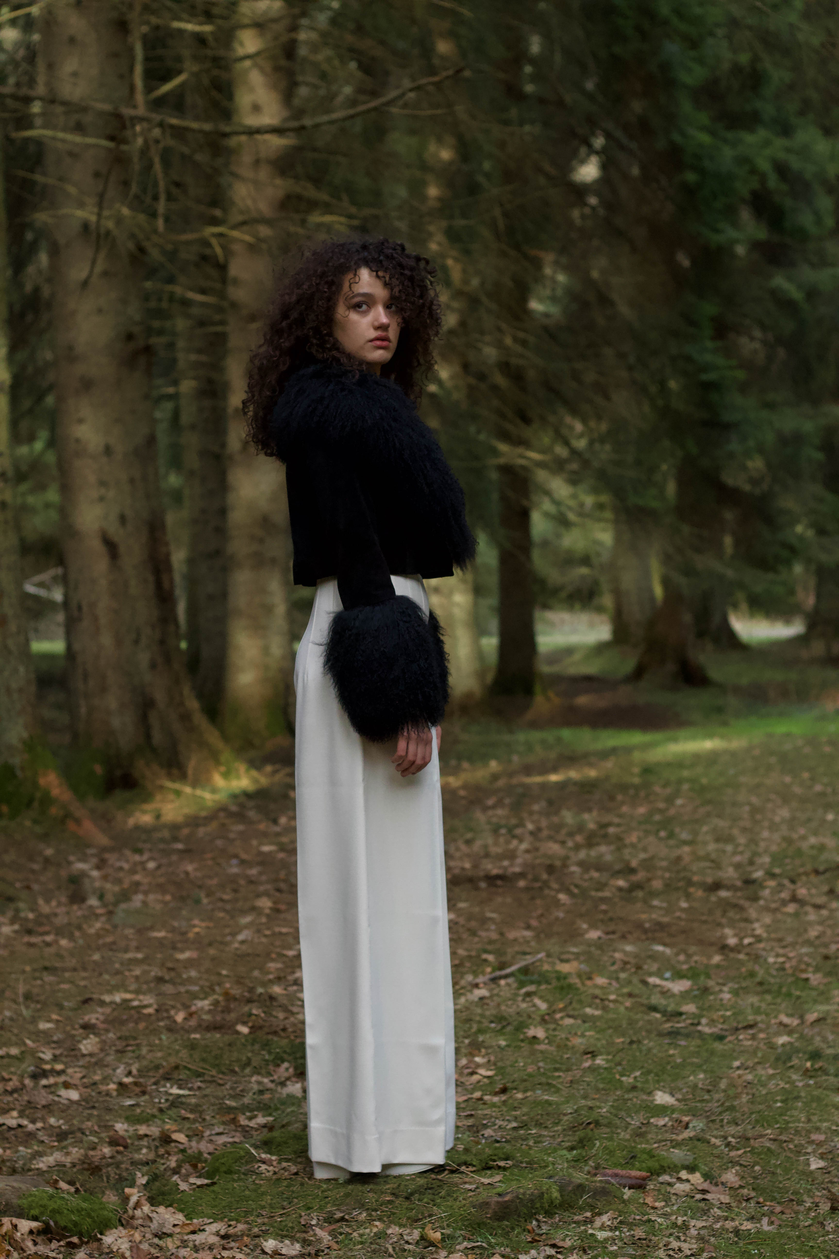  A sophisticated black genuine suede cropped jacket coat from Josephine Jones, featuring a luxurious Mongolian collar and cuffs. Perfect for adding a touch of elegance to any outfit.